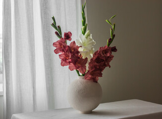 Bouquet of white and pink gladioli on the table in the living room