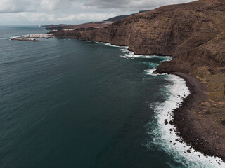 Obraz premium Aerial View of Rocky Coastline and Ocean Waves
