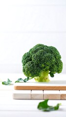 Fresh broccoli head on a white cutting board