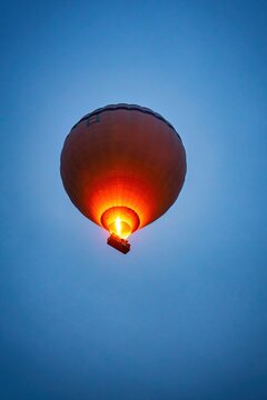 Hot air balloon flying in Cappadocia at sunrise with blue sky