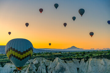 Colorful hot air balloons flying over Cappadocia at sunrise in Turkey
