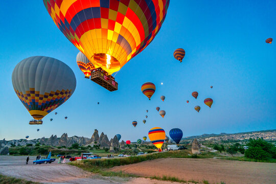 Colorful hot air balloons flying over Cappadocia at sunrise in Turkey