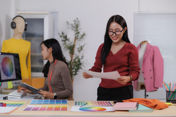 Fashion designers working with color palettes and clothing sketches in a studio