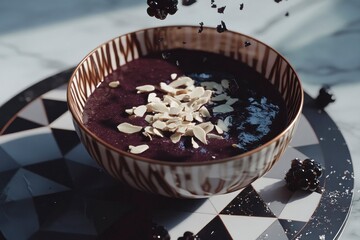 smoothie in bowl with black currant base and almond on  blurred background . Healthy breakfast concept.