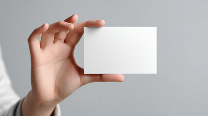 Fototapeta premium Hand holding blank white card mockup on neutral background