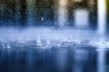 heavy raining make many small splash crown from water droplets drop down to the concrete floor in blue tone color scene