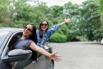 Obraz premium Happy tourists waving from car window during road trip