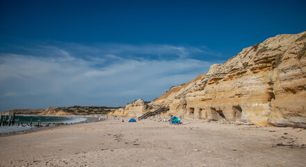 Old wooden jetty ruins on Willunga Beach, South Australia, with turquoise ocean and beach