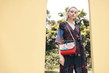 Stylish young woman posing in floral dress.
