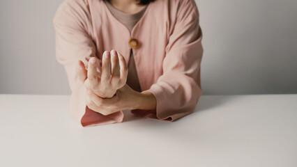 Asian business woman massaging wrist in pain Caused by working on a computer keyboard for a long...