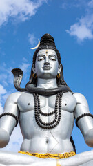 Realistic statue of Lord Shiva under vibrant blue sky showcasing divine aura