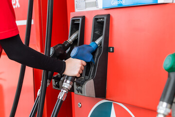 Closeup gas station staff worker hand holding fuel nozzle for refill car fuel, Petroleum business