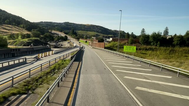 Personal perspective view through bus front window on E39 highway in Norway, driving past roadworks site.