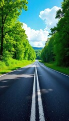 Obraz premium A winding asphalt road disappears into the distance, flanked by lush green trees and a vibrant blue sky The perspective creates a sense of journey and exploration , vanishing point, countryside