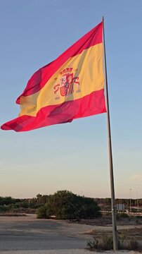 wielka Hiszpańska flaga łopocze na wietrze niebieskie niebo