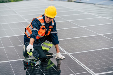 Worker installs solar panels on rooftop during daytime with safety gear and tools