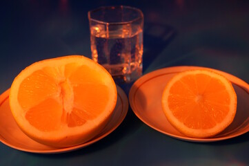Chopped grapefruit and a glass of water on a blue background.
