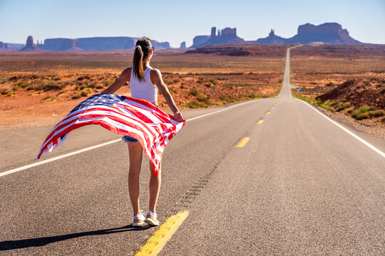 Young Woman Holding USA Flag on Lonely Monument Valley Road