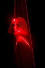 Profile of a young Asian woman with red light effects.