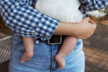 Mother holding baby with bare feet, close-up of bonding and tenderness