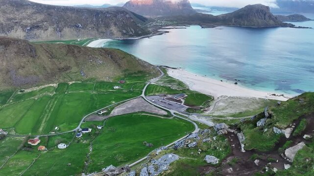 Midnight aerial of Haukland beach with Mannen cliffside path showing wear from heavy tourism