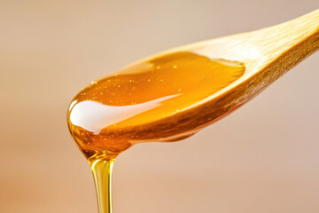 Sweet golden honey pours smoothly from a natural wooden spoon, forming a thick, shiny, and delicious stream in a warm setting.