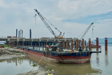 River wharf under construction flanked by a moored floating wharf