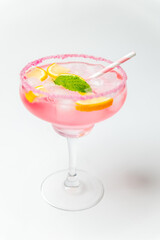 A cold pink refreshing drink with lemon and mint, chilled with ice cubes, decorated with a pink sugar rim. The best summer drink, rose lemonade on white background.