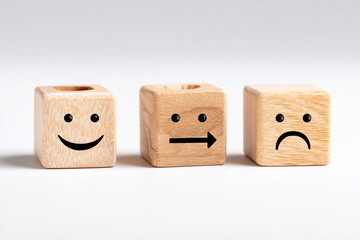 Three wooden blocks with different facial expressions representing emotions, isolated on white background