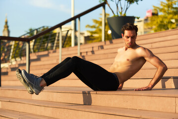Man exercises on outdoor steps in a city setting during golden hour of sunset