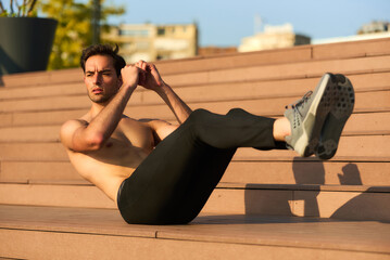 Man exercises using bodyweight workout on outdoor steps in the morning sunlight