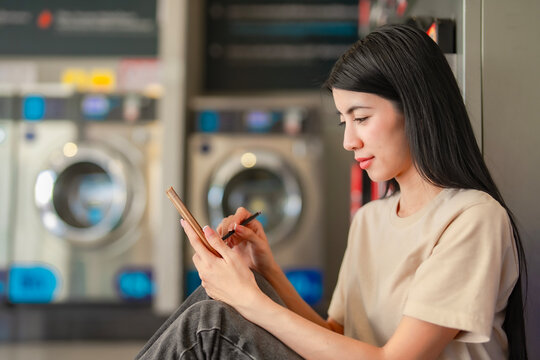 Close-up of a young woman writing on her smartphone with a pen stylus. Focused expression during creative digital work or note-taking. - Powered by Adobe