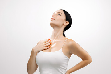 Caucasian woman with clear skin poses gracefully against a white background, showcasing natural beauty and confidence, emphasizing skincare and self-care concepts