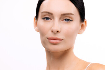 Close-up portrait of a woman with clear skin and natural makeup, showcasing beauty and confidence against a white background, emphasizing the essence of modern cosmetology and skincare