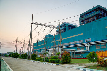 Obraz premium Industrial panorama showcasing a large power plant generating energy with electrical power lines