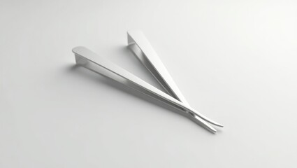 Pair of metallic tweezers on a light background.