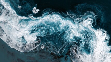 Aerial view of dynamic ocean waves crashing and swirling with white foam patterns on deep blue water
