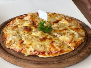 Table top view Hawaiian pizza on a wooden board