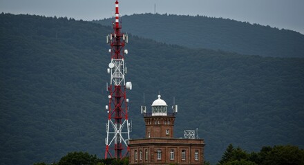 Communication tower and brick radar tower against green mountains