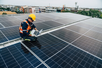 Solar energy technician conducts system check on rooftop with laptop during daylight hours in urban area