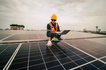Technician inspects solar panels on rooftop in industrial area during cloudy afternoon