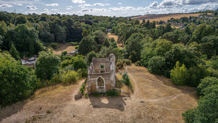 Aerial view of the stark, aged ruin stands in contrast to the dense, verdant forest surrounding it, Guildford, Surrey, United Kingdom.