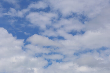 Blue sky with white clouds in the daytime background.