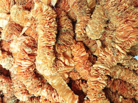 Close-up detail of a pile of tangled orange faded fabric garland with variegated color