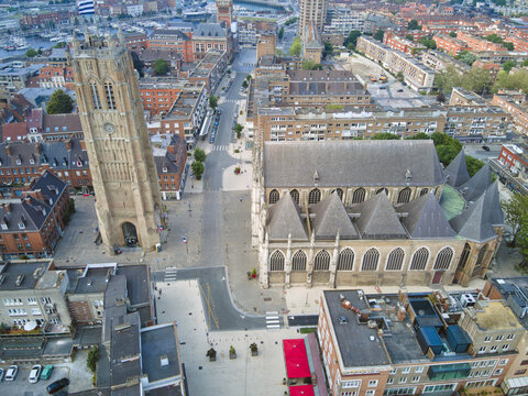 Aerial view of the historic Saint-&Atilde;&permil;loi Church and its towering belfry cast long shadows on the cobblestone square, Dunkirk, France.