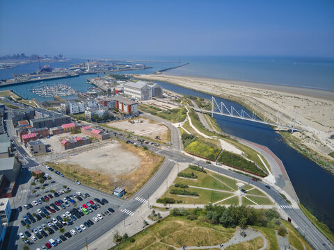 Aerial view of a vibrant coastal scene where modern architecture meets the tranquil sea near the Port of Dunkirk and the sandy beach, Dunkirk, France.