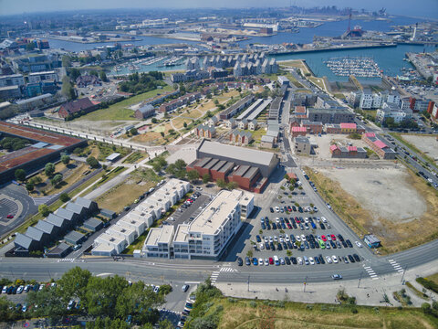 Aerial view of a vibrant urban landscape where modern buildings meet the industrial port, creating a tapestry of textures and tones, Dunkirk, France.