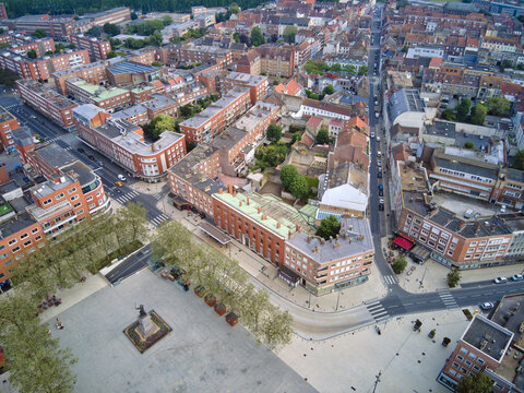 Aerial view of the Place Jean Bart, with its statue standing proudly over the paved square, surrounded by red-brick buildings, Dunkirk, France.