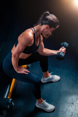 Strength training with dumbbells involves a woman, improving fitness and energy in a dedicated gym space.