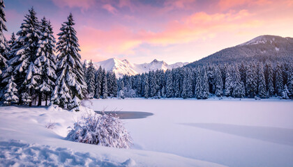 Serene winter landscape with snow-covered trees, frozen lake, and majestic mountains under a soft pink sky.